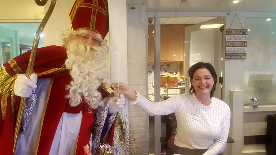 Sinterklaas begroet de receptioniste van de Posten