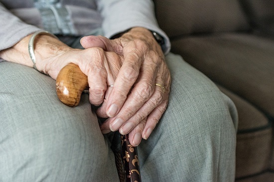 Oude vrouw zit te wachten in stoel