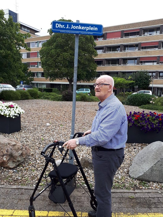 de heer Jonker bij het straatnaambord van 'zijn' plein bij de Posten