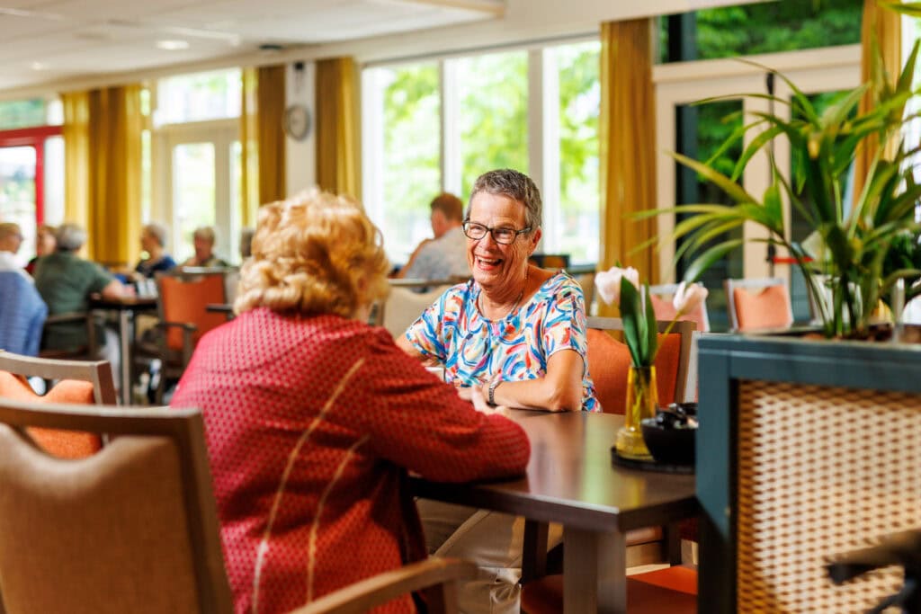 Vrijwilliger met bewoner in restaurant