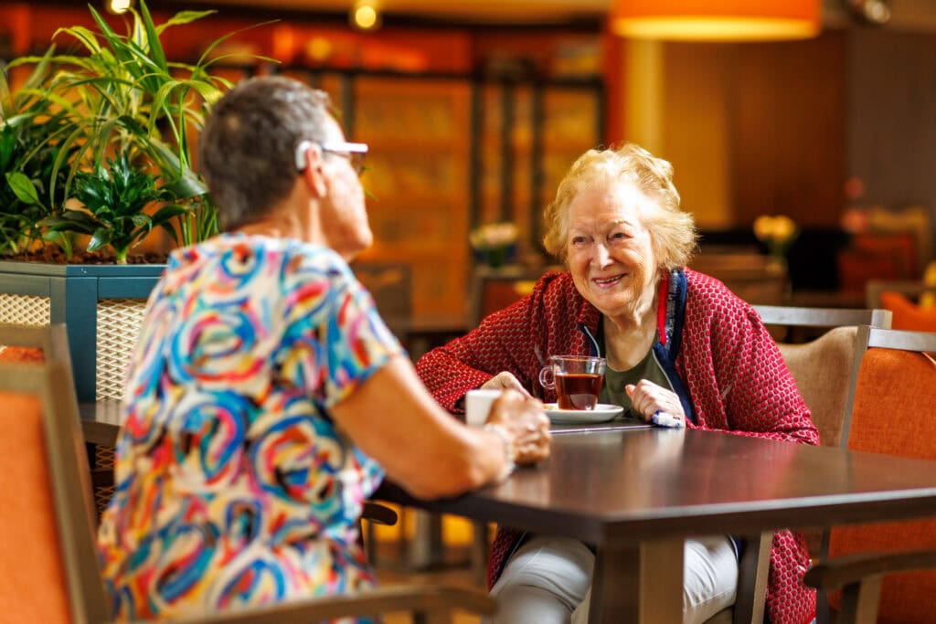 Bewoner en vrijwilliger drinken thee en koffie