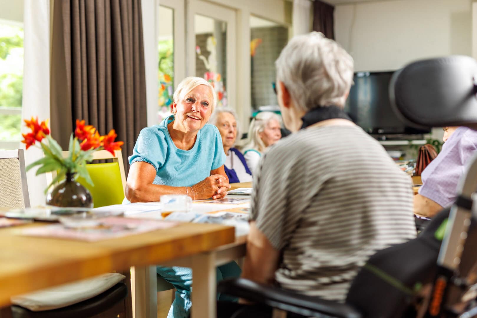 vrijwilliger en bewoner aan tafel